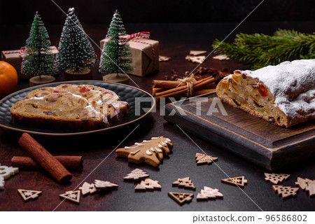 Christmas pie stollen with marzipan, berries and nuts on a dark concrete background 96586802