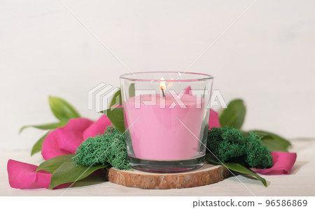 floral fragranced burning candle with green leaves, moss and petals. home fragrances, cozy home ambience, romantic decor for valentines. floral fragranced burning candle with green leaves, moss and petals. home fragrances, cozy home ambience, romantic decor for valentines. 96586869