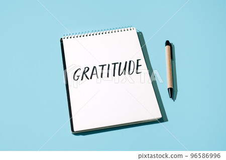 How to Practice Gratitude. Word Gratitude in open notebook on table. Notice good things, appreciate good things. Express gratitude to yourself. Word Gratitude in open notebook on blue background 96586996