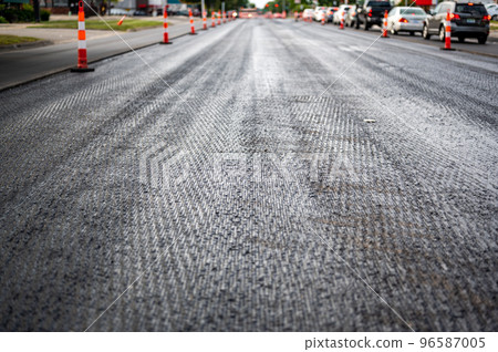 Low angle shot across a scarified street under construction with lanes on either side blocked off. Low angle shot across a scarified street under construction with lanes on either side blocked off. 96587005
