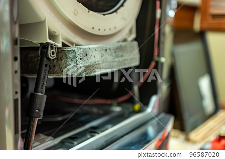 Selective Focus on the gasket mount of a front loading washing machine being serviced 96587020