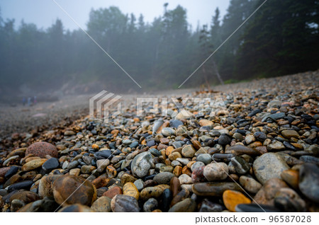 Multi-colored round rocks on Little Hunters Beach in Acadia National Park, Maine. Tide coming in as waves crash.  96587028