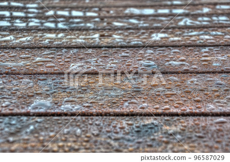 Water beading up on a freshly stained wooden deck 96587029