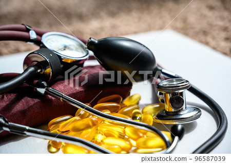 Omega 3 fish oil supplements with stethoscope and blood pressure cuff Omega 3 fish oil supplements with stethoscope and blood pressure cuff 96587039