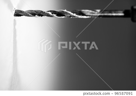 Selective focus on point of penetration of a drill bit making a pilot hole in drywall Selective focus on point of penetration of a drill bit making a pilot hole in drywall 96587091