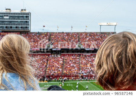 Caucasian girl looking at blurred background of football game 96587146