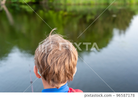 Boy on a fishing with blue water in background Boy on a fishing with blue water in background 96587178