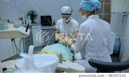Dentist and patient in the clinical office. Dental care concept. Dentist examining teeth with medical instruments. Professional dentist working in gloves with patients with teeth Dentist and patient in the clinical office. Dental care concept. Dentist examining teeth with medical instruments. Professional dentist working in gloves with patients with teeth 96587242