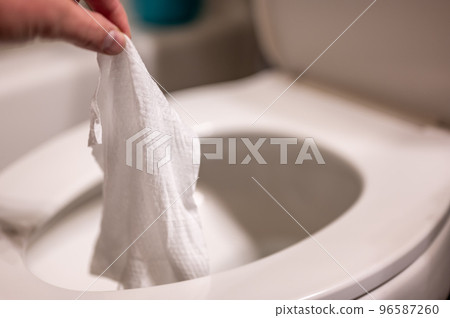 Disposable wipes being flushed down a toilet where they can cause clogging and problems with wastewater treatment. Disposable wipes being flushed down a toilet where they can cause clogging and problems with wastewater treatment. 96587260