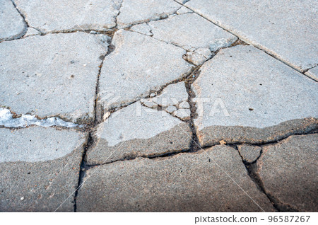 Cracked and damaged residential concrete sidewalk 96587267