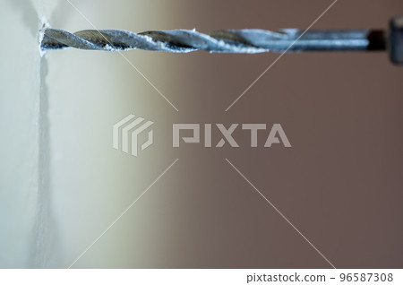 Selective focus on point of penetration of a drill bit making a pilot hole in drywall Selective focus on point of penetration of a drill bit making a pilot hole in drywall 96587308