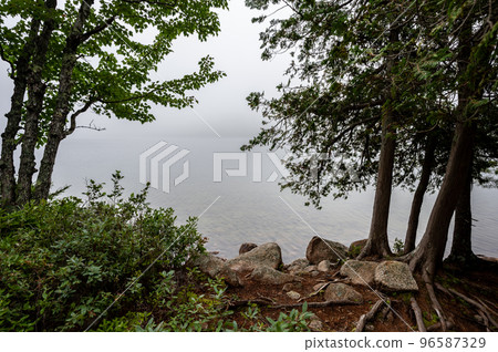 Waters edge of Jordan Pond in Acadia National Park, Maine, USA with fog setting into the distance  96587329