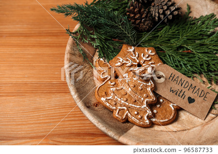 Inexpensive Christmas Gifts, Cheap Xmas budget Gift Ideas. Xmas homemade gingerbread cookies with ribbon, fir-tree and Handmade with love label on wooden table Inexpensive Christmas Gifts, Cheap Xmas budget Gift Ideas. Xmas homemade gingerbread cookies with ribbon, fir-tree and Handmade with love label on wooden table 96587733