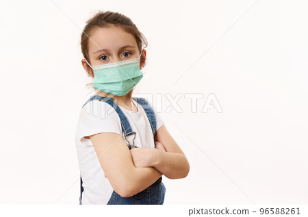 Adorable little girl in protective mask, isolated on white. Virus symptoms. Concept of air pollution, epidemic, influenza, protection from disease. Flu illness. Pediatrics. Medical care. Insurance. 96588261
