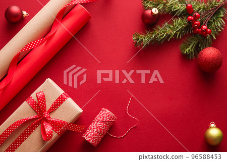Christmas preparation, boxing day and holidays gift giving, xmas craft paper and ribbons for gifts boxes on red background as wrapping tools and decorations, diy presents as holiday flat lay design Christmas preparation, boxing day and holidays gift giving, xmas craft paper and ribbons for gifts boxes on red background as wrapping tools and decorations, diy presents as holiday flat lay design 96588453