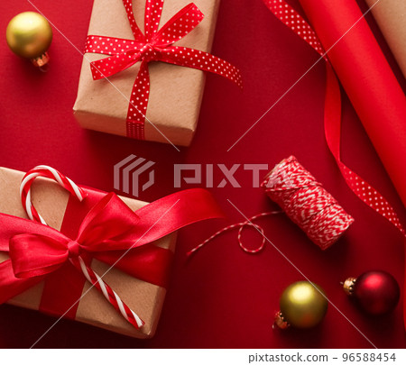Christmas preparation, boxing day and holidays gift giving, xmas craft paper and ribbons for gifts boxes on red background as wrapping tools and decorations, diy presents as holiday flat lay design Christmas preparation, boxing day and holidays gift giving, xmas craft paper and ribbons for gifts boxes on red background as wrapping tools and decorations, diy presents as holiday flat lay design 96588454