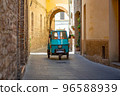 Azul blue tricycle driving in an empty street in Spello. 96588939
