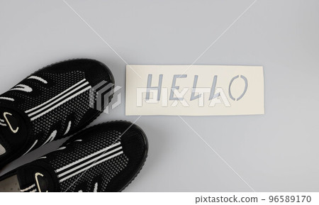The word hello on a white background next to casual summer shoes.World Greetings Day. The day of winning friends. 96589170