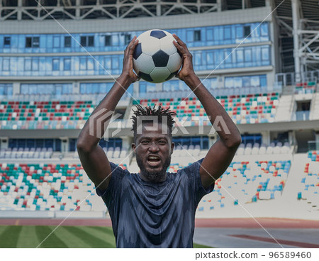 Football Player Holding Football With Both Hands Stock Photo