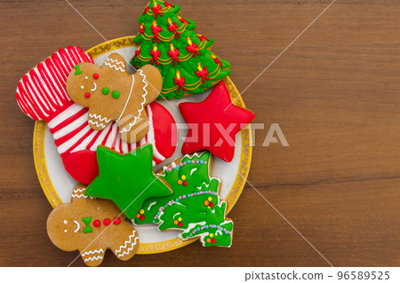 Plate with tasty Christmas cookies on wooden table 96589525