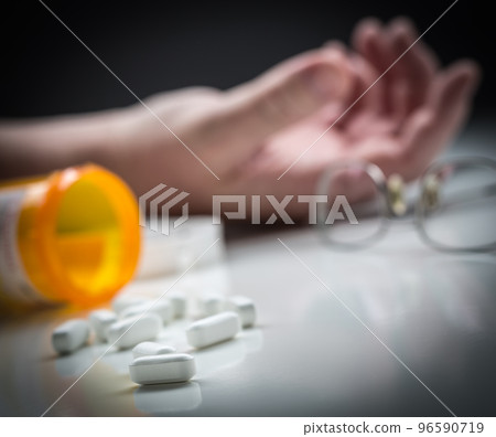 Man Passed Out on Floor Behind Scattered Drugs and Medicine Bottle. 96590719