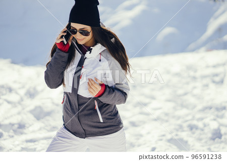 young and active brunette in the snowy mountains with telephone young and active brunette in the snowy mountains with telephone 96591238