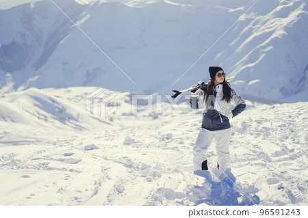young and active brunette skiing in the snowy mountains 96591243
