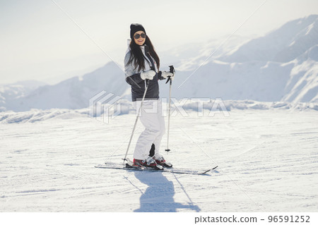 young and active brunette skiing in the snowy mountains 96591252
