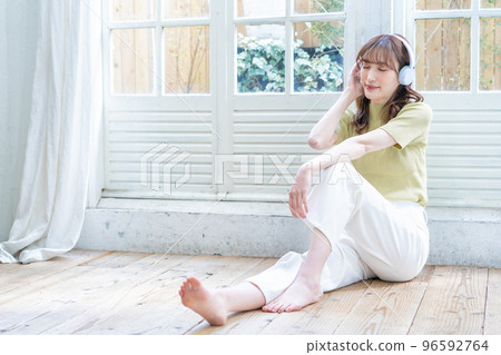 沉浸在木地板上的音樂中的年輕女人 96592764