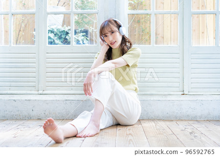 沉浸在木地板上的音樂中的年輕女人 96592765