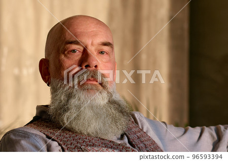mature bearded man sitting in a chair. mature bearded man sitting in a chair. 96593394