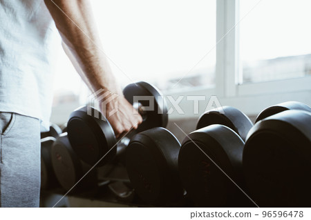 Wellness men lifting dumbbell weight hand in gym Wellness men lifting dumbbell weight hand in gym 96596478