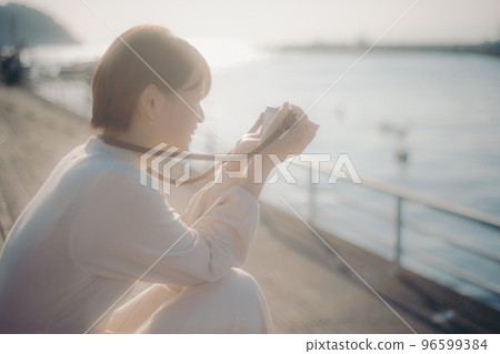 手持無反光鏡相機的年輕女子的照片 96599384
