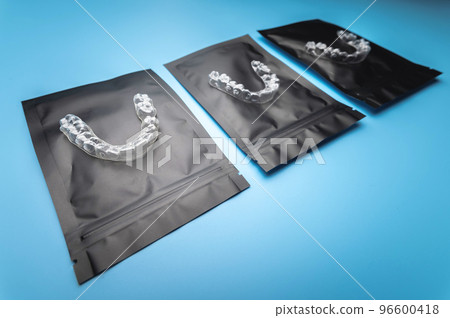 corrective aligners for the beauty of teeth lie on a black package. special storage bags. dentistry and health care corrective aligners for the beauty of teeth lie on a black package. special storage bags. dentistry and health care 96600418