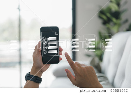 A businessman works with a smartphone. Check marks in the check boxes successful completion of business tasks. Digital marketing statistics. Business management is the goal of strategy. A businessman works with a smartphone. Check marks in the check boxes successful completion of business tasks. Digital marketing statistics. Business management is the goal of strategy. 96601922