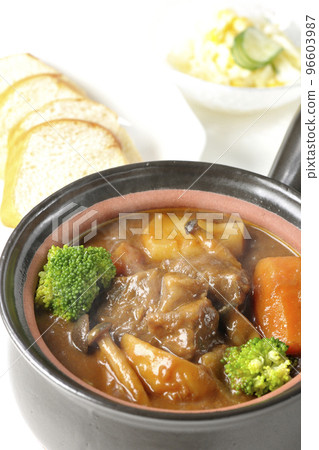 滾燙的燉牛肉,在鍋中加入大量配料,如西蘭花、胡蘿蔔和姬菇、沙拉和麵包 滾燙的燉牛肉,在鍋中加入大量配料,如西蘭花、胡蘿蔔和姬菇、沙拉和麵包 96603987