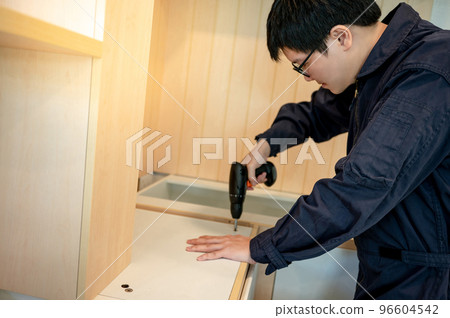 Asian male furniture assembler installing kitchen counter Asian male furniture assembler installing kitchen counter 96604542