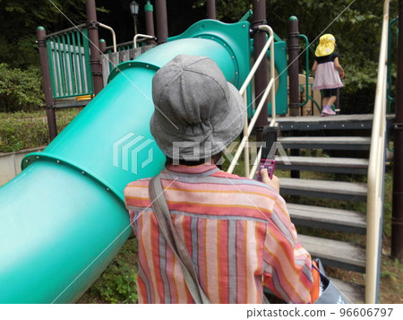 一位祖母看著她的孫子孫女在公園玩耍 96606797