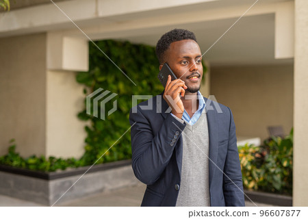 Portrait of handsome black African businessman talking on phone Portrait of handsome black African businessman talking on phone 96607877