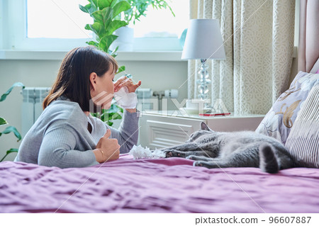 Woman sneezing allergic to domestic cat fur 96607887
