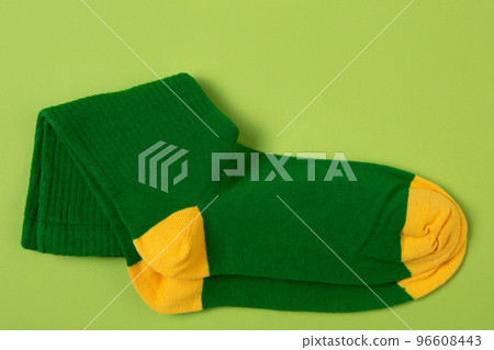 A pair of green socks with yellow toes and heels, on a green background A pair of green socks with yellow toes and heels, on a green background 96608443
