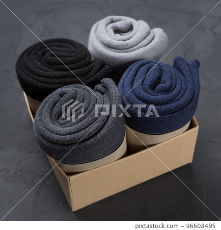 Four rolled up men's socks in a box, concept 96608495