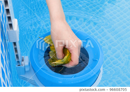 girl cleans skimmer for the frame pool. Contaminated pool cleaning concept 96608705