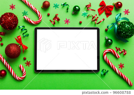 Top view of empty tablet on Christmas background made of new year decorand festive decorations. New year holiday concept. Mockup Top view of empty tablet on Christmas background made of new year decorand festive decorations. New year holiday concept. Mockup 96608788