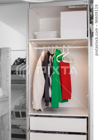 Clothes hang on a hanger in the closet. Clothes hang on a hanger in the closet. 96609119