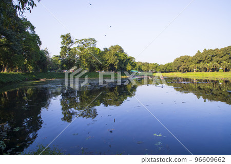 Natural landscape view Reflection of trees in the lake water against blue sky Natural landscape view Reflection of trees in the lake water against blue sky 96609662