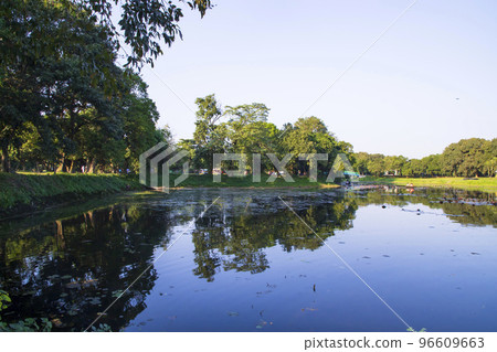 Natural landscape view Reflection of trees in the lake water against blue sky Natural landscape view Reflection of trees in the lake water against blue sky 96609663