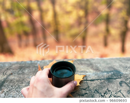 Drinking coffee outdoors in the park is a nice chance to warm up and feel good 96609693