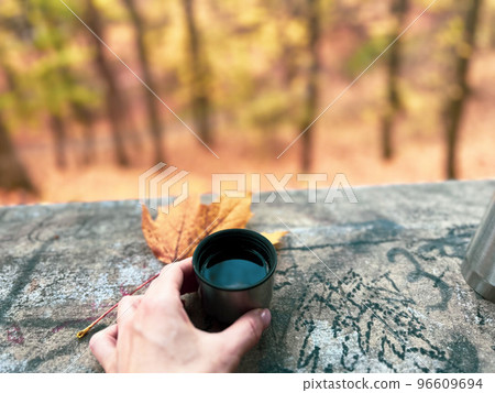 Drinking coffee outdoors in the park is a nice chance to warm up and feel good 96609694