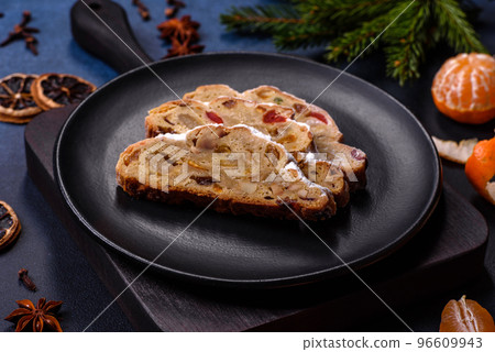 Delicious festive New Year's pie with candied fruits, marzipan and nuts on a dark concrete background 96609943